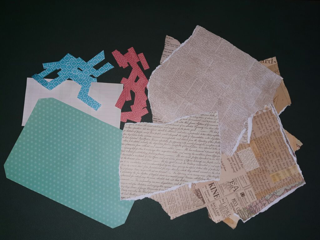 A pile of ripped-out and cut-up papers from the origami book and scrapbooking pages.